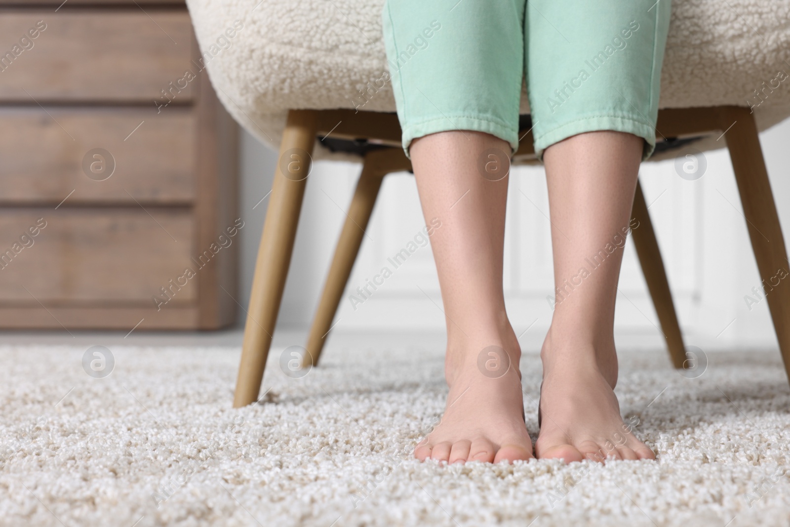 Photo of Woman on soft light brown carpet at home, closeup. Space for text