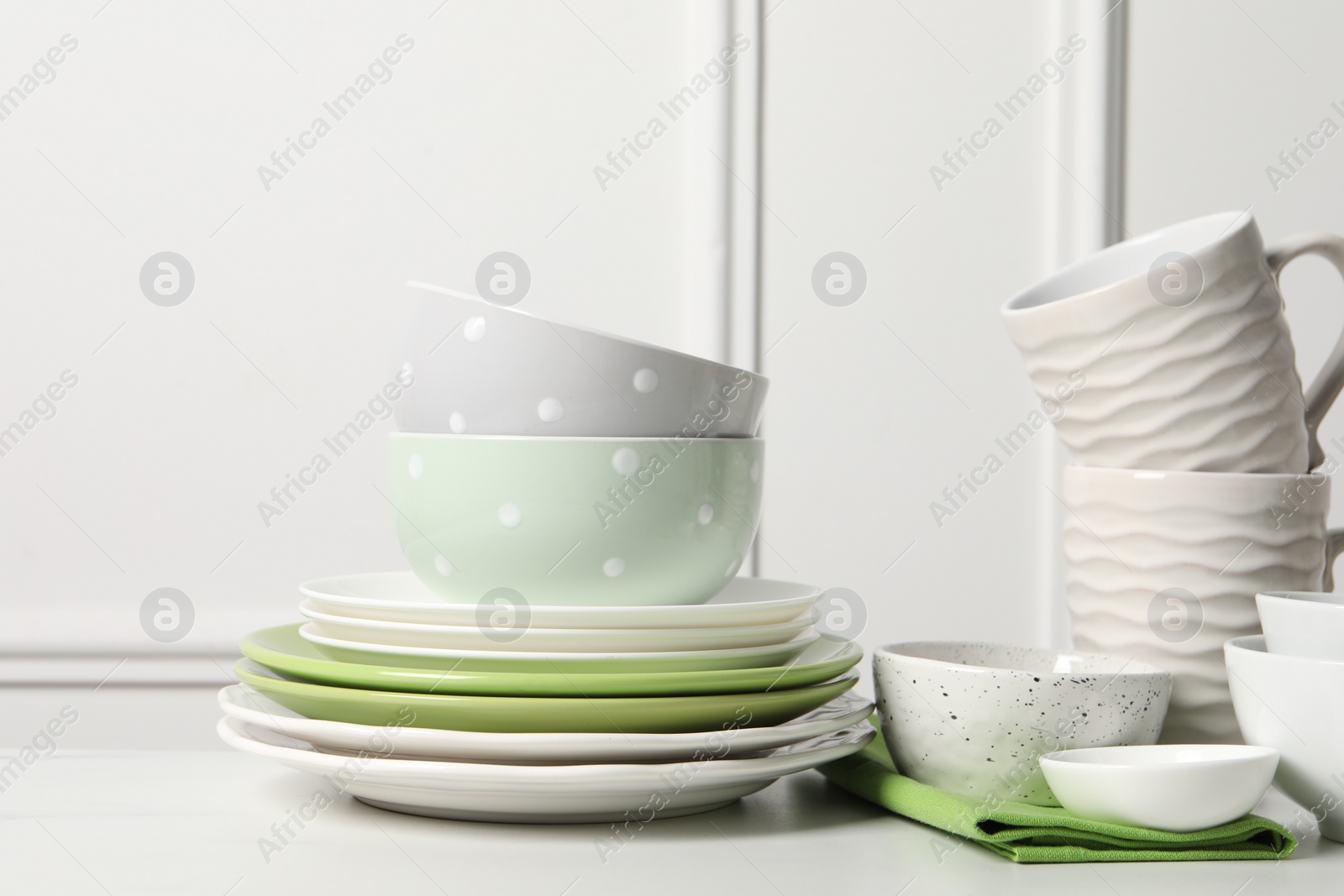 Photo of Beautiful ceramic dishware and cups on white table