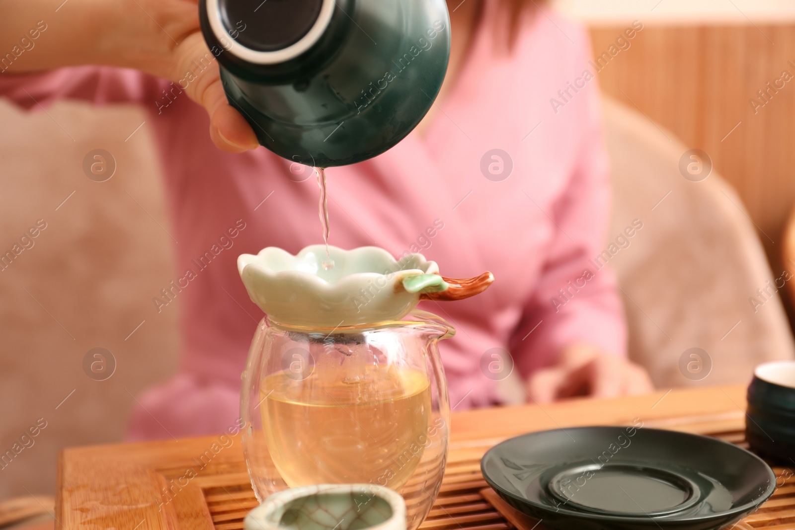 Photo of Master conducting traditional tea ceremony at table, closeup