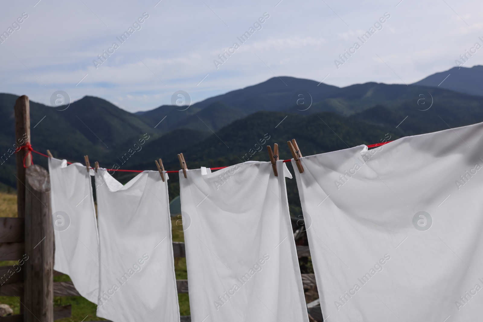 Photo of Washing line with clean laundry and clothespins in mountains