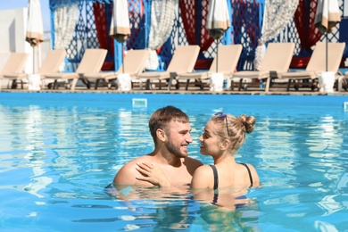 Happy young couple in swimming pool at resort