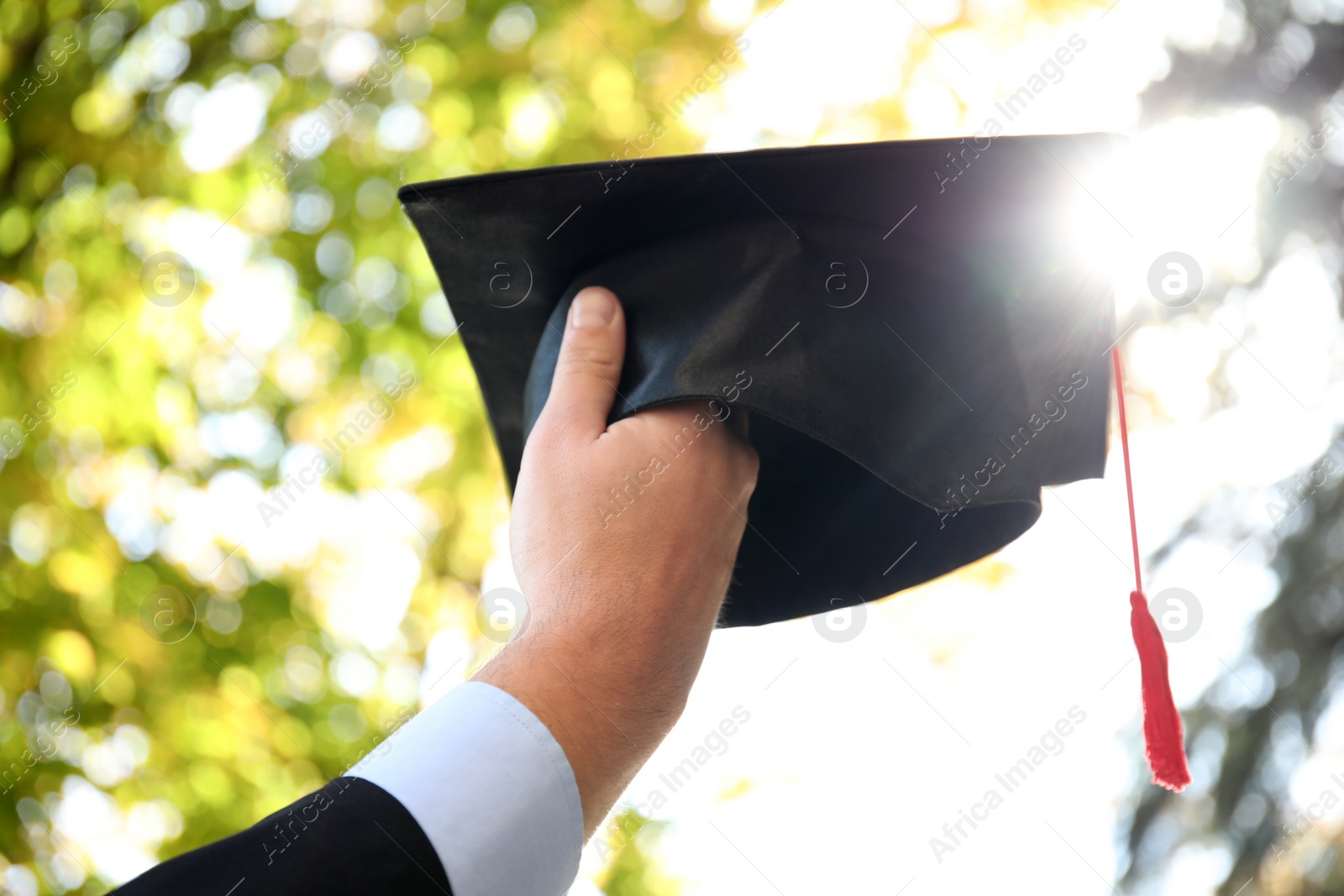 Photo of Student with graduation hat outdoors on sunny day, closeup