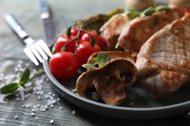 Delicious grilled meat and vegetables served on wooden table, closeup