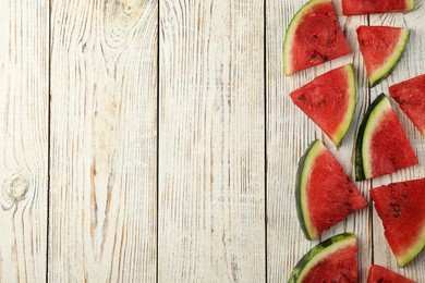 Photo of Slices of delicious ripe watermelon on white wooden table, flat lay. Space for text