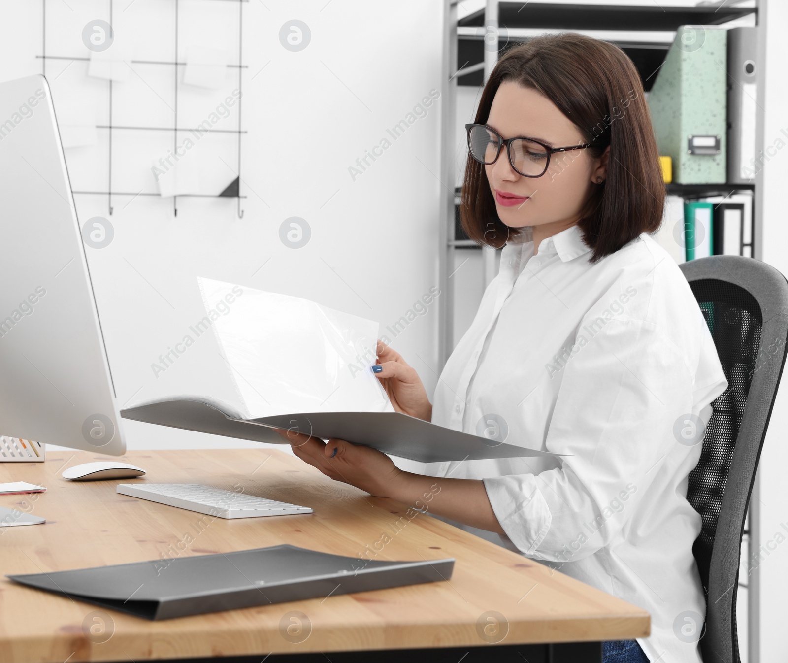 Photo of Young intern working at table in modern office