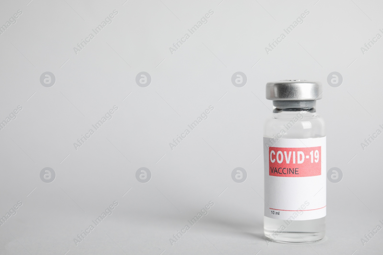 Photo of Vial with coronavirus vaccine on light background, space for text