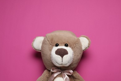 Photo of Cute teddy bear on pink background, top view. Space for text