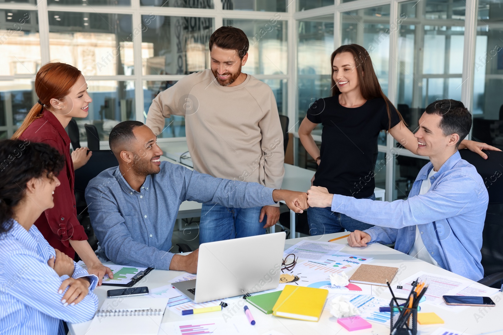 Photo of Team of employees working together at table in office. Startup project