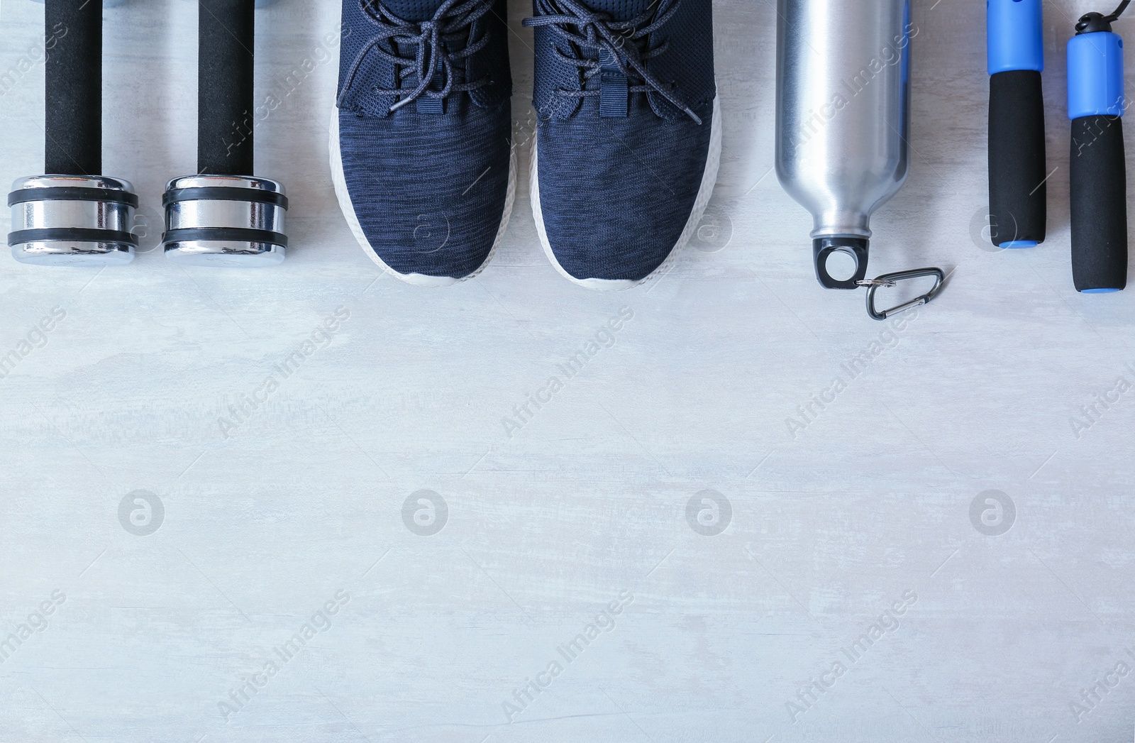 Photo of Flat lay composition with fitness equipment and space for text on gray background