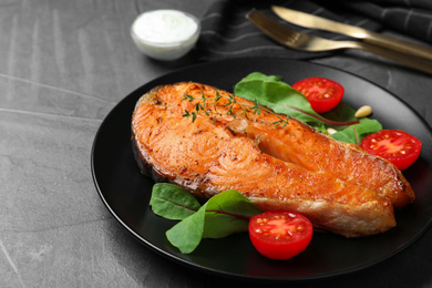 Delicious roasted fish served on grey table