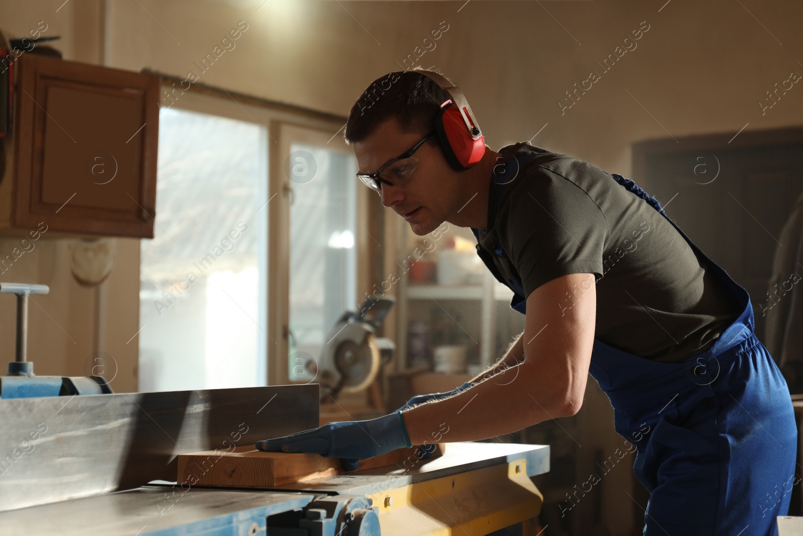 Photo of Professional carpenter working with wood in shop