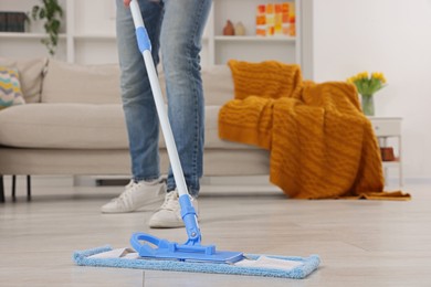 Photo of Spring cleaning. Man with mop washing floor at home, closeup