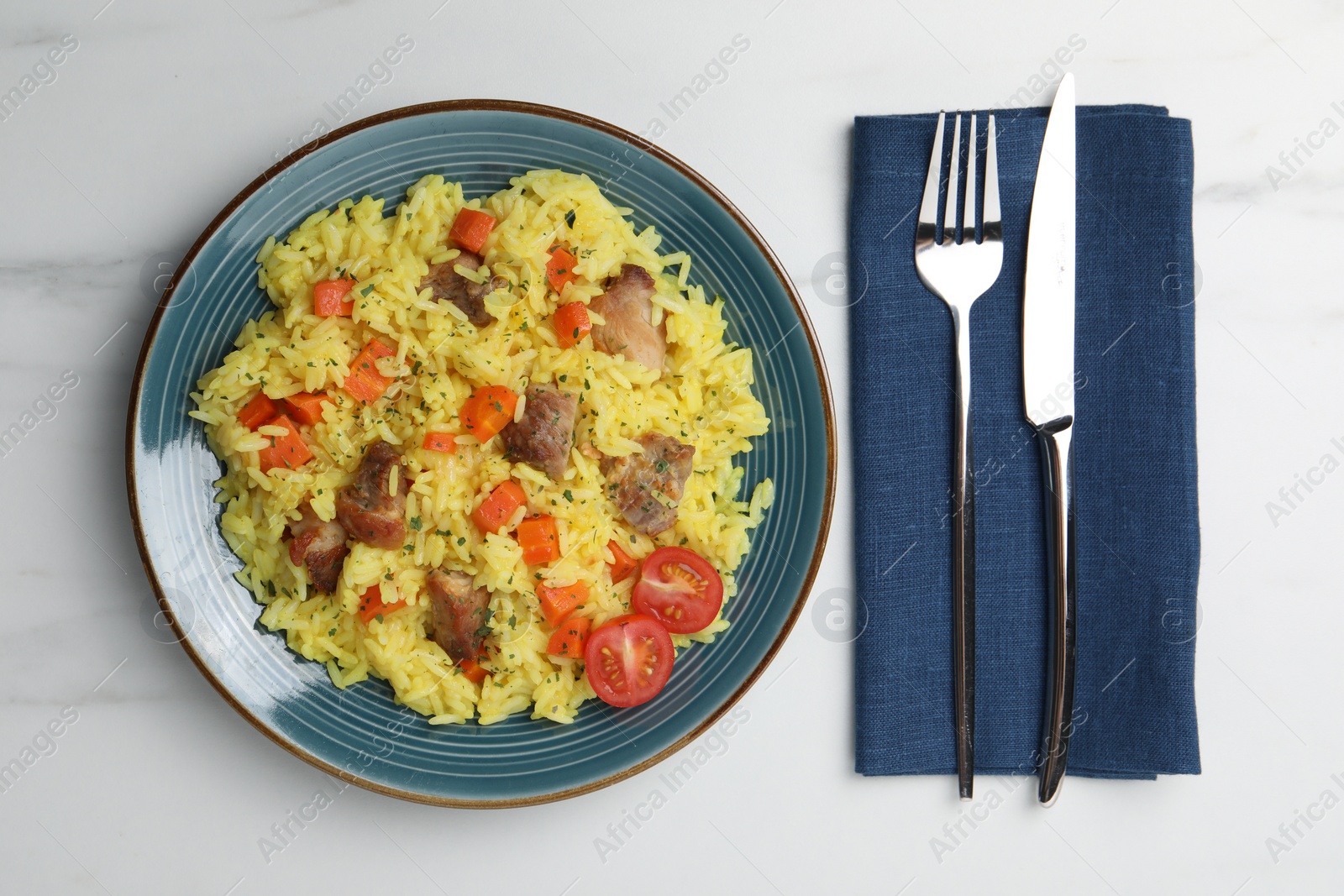 Photo of Delicious pilaf with meat served on white marble table, flat lay