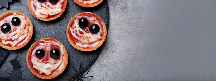 Image of Cute monster tartlets served on grey table, flat lay with space for text. Banner design