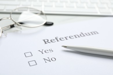 Referendum ballot with pen and glasses on table, closeup