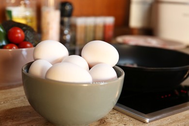 Many fresh eggs on wooden countertop in kitchen, closeup. Ingredient for breakfast