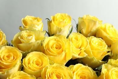 Photo of Beautiful bouquet of yellow roses on light grey background, closeup