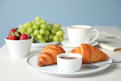 Photo of Delicious breakfast with croissants and chocolate served on light table
