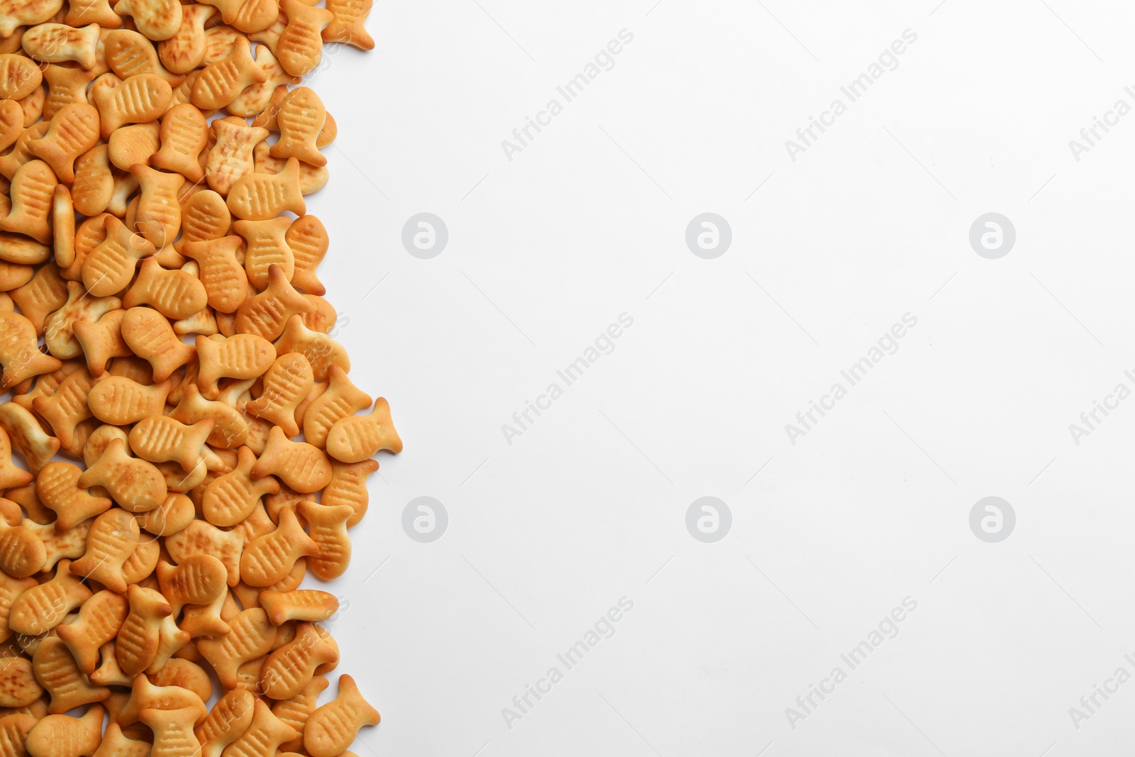Photo of Delicious goldfish crackers on white background, top view