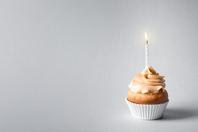 Photo of Delicious birthday cupcake with candle and space for text on gray background