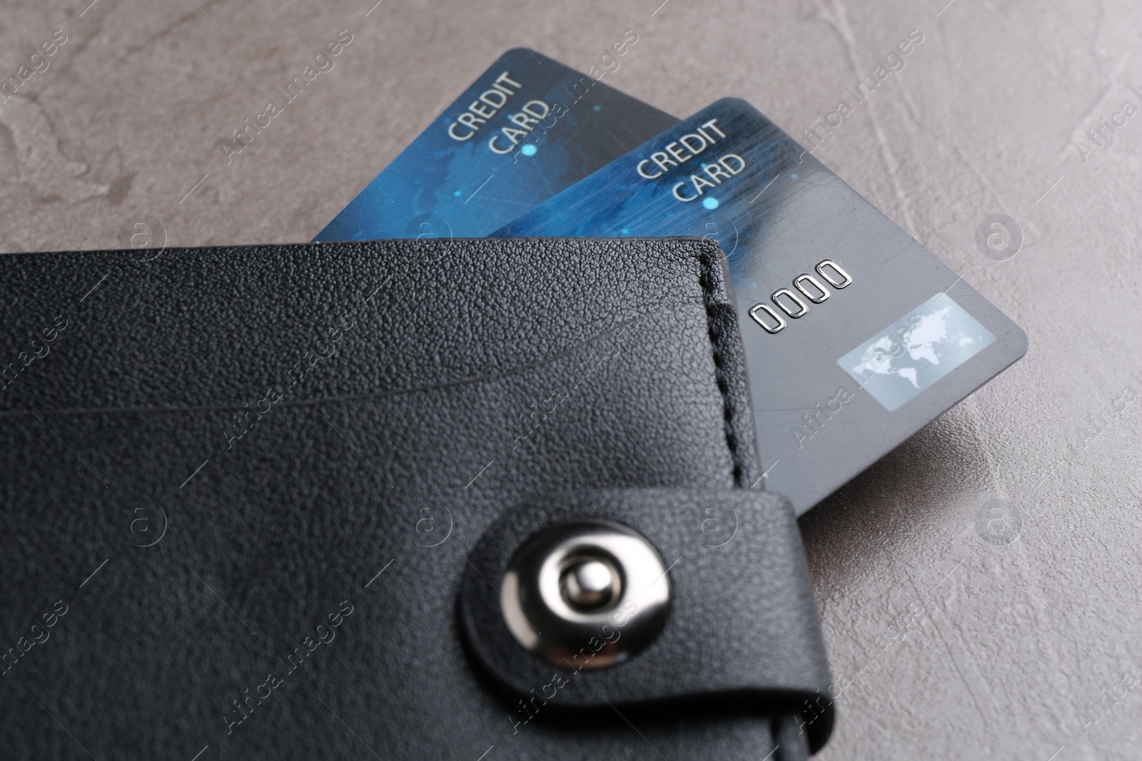 Photo of Credit cards in leather wallet on grey textured table, closeup