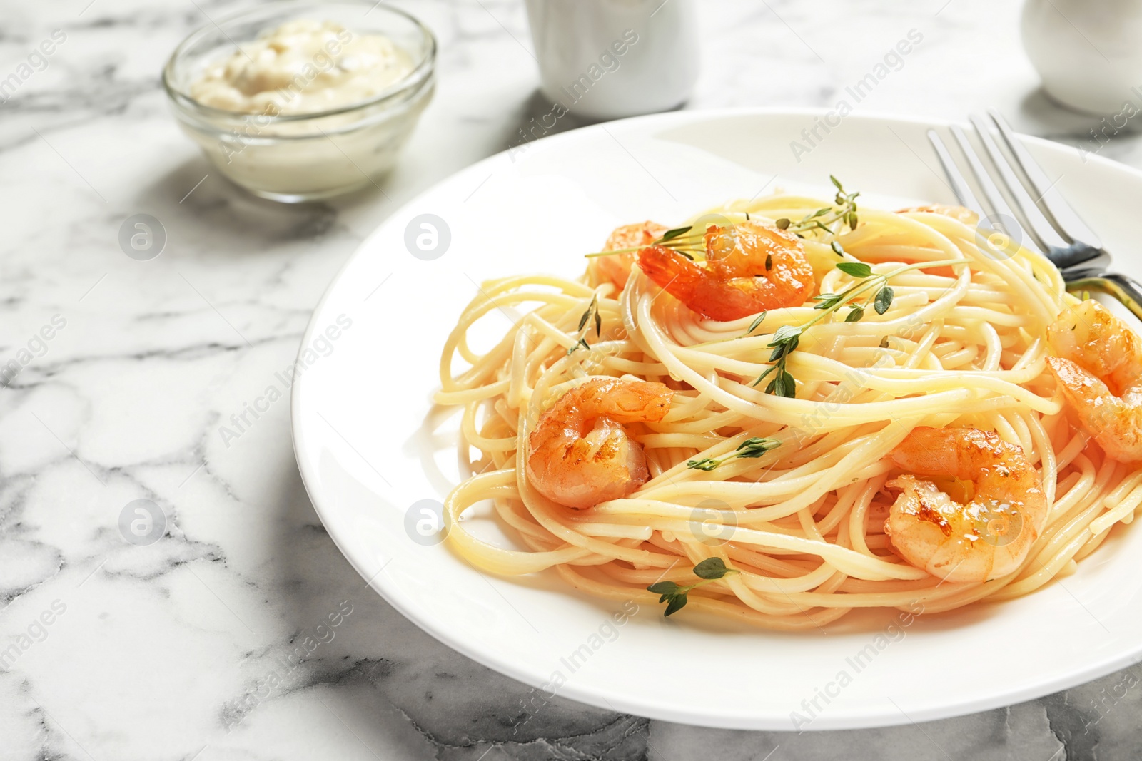 Photo of Plate with spaghetti and shrimps on table