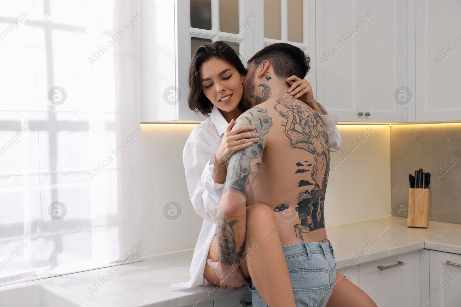 Photo of Passionate young couple having sex in kitchen