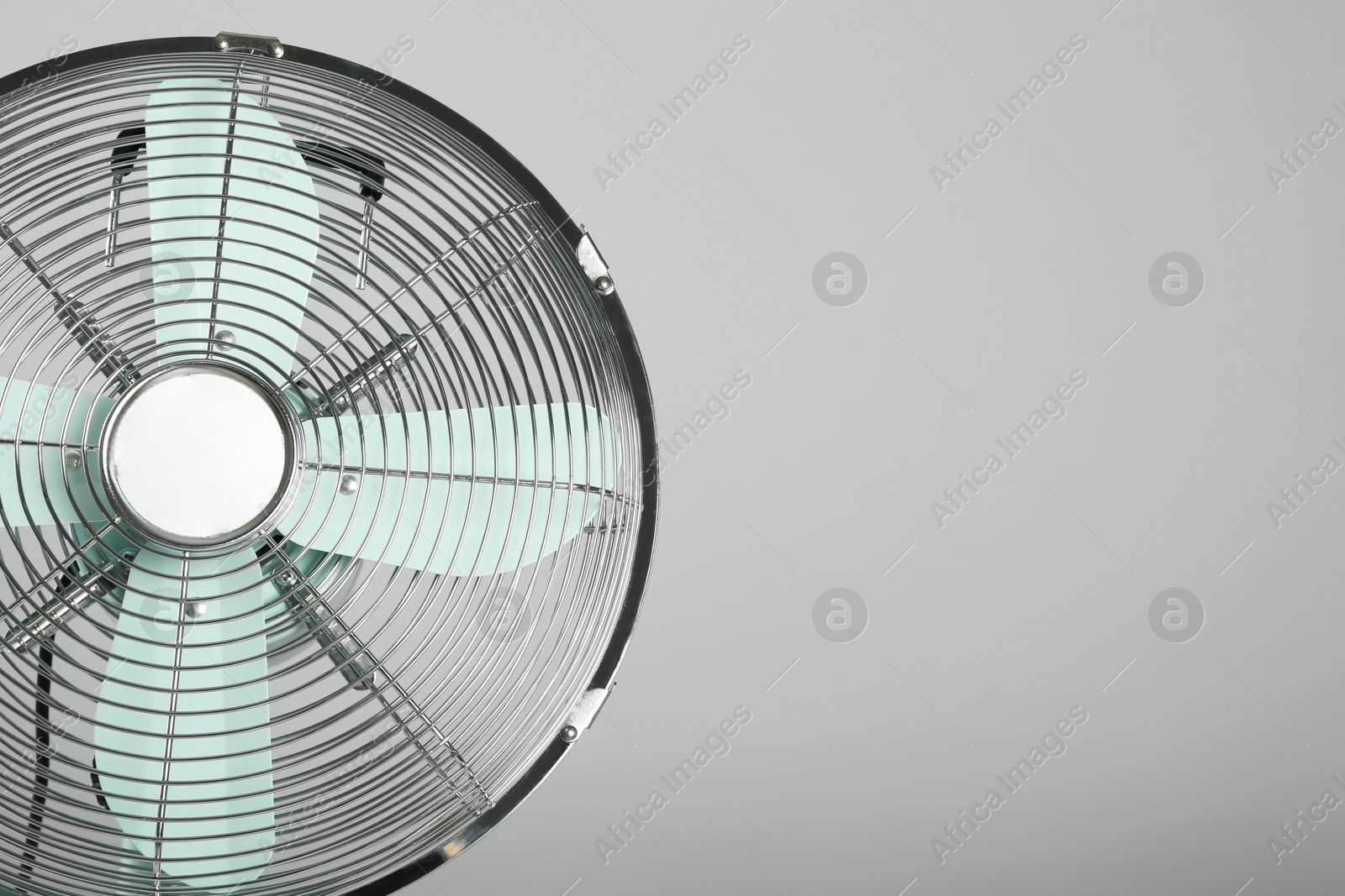 Photo of Electric fan on light grey background, space for text. Summer heat