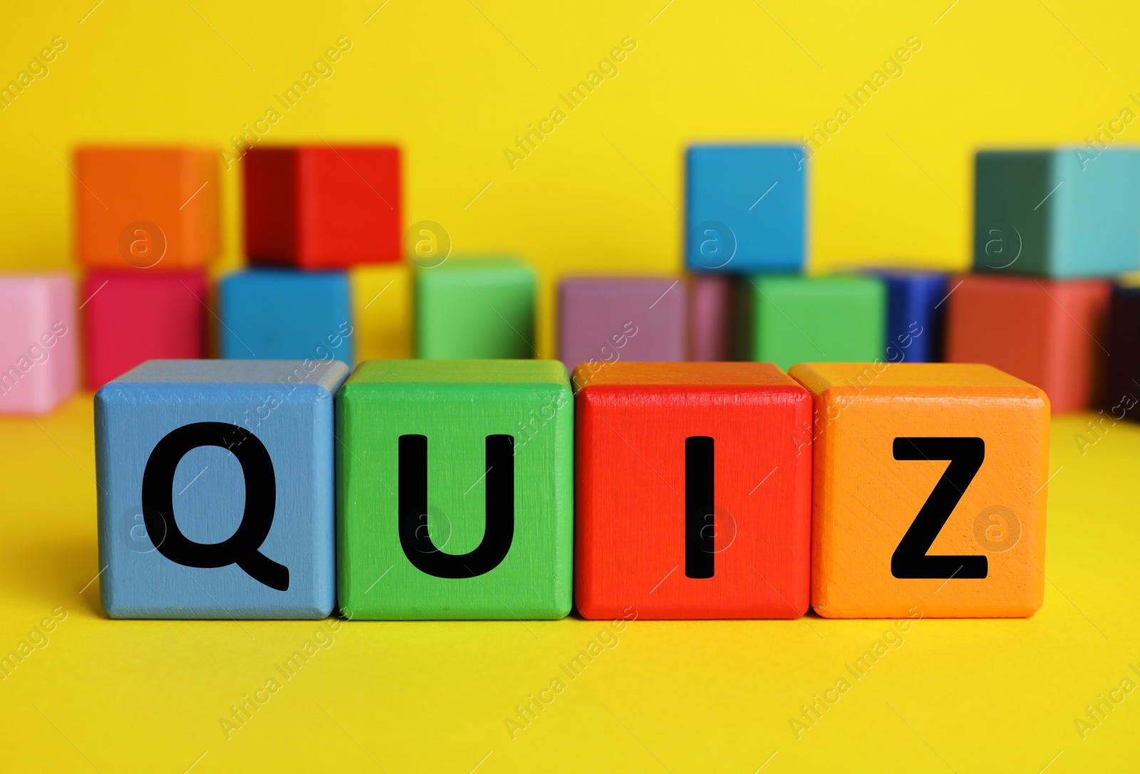 Photo of Colorful cubes with word Quiz on yellow background. Space for text