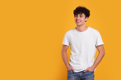 Photo of Portrait of handsome young man on orange background. Space for text