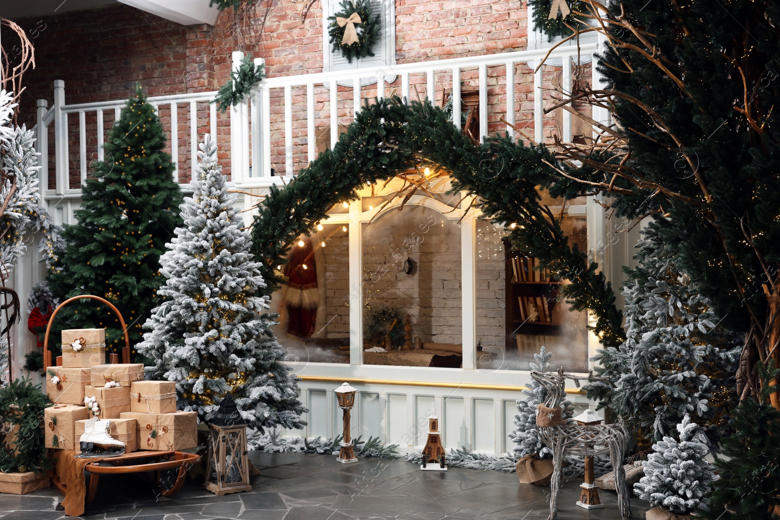 Photo of Beautiful Christmas trees, gift boxes, skates and festive decor indoors. Interior design