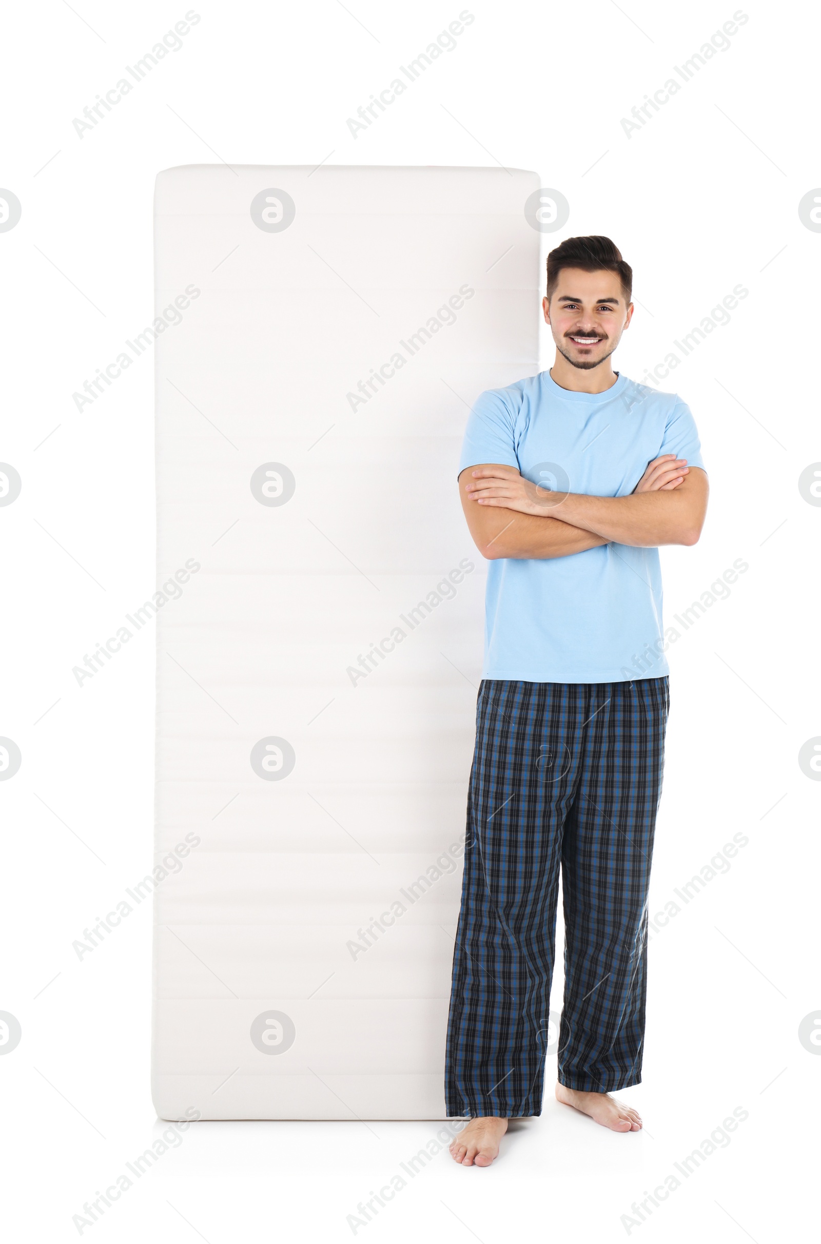 Photo of Young man with comfortable mattress isolated on white