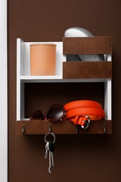 Photo of Stylish hanger for keys on brown wall in hallway