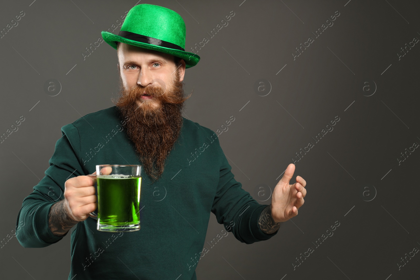 Photo of Man with green beer on grey background. St. Patrick's Day celebration