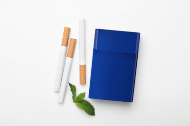 Menthol cigarettes, pack and mint on white background, flat lay