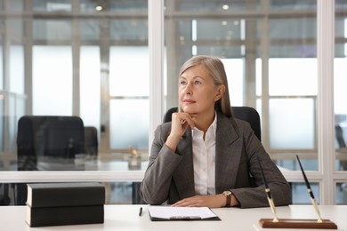 Photo of Beautiful woman at table in office. Lawyer, businesswoman, accountant or manager