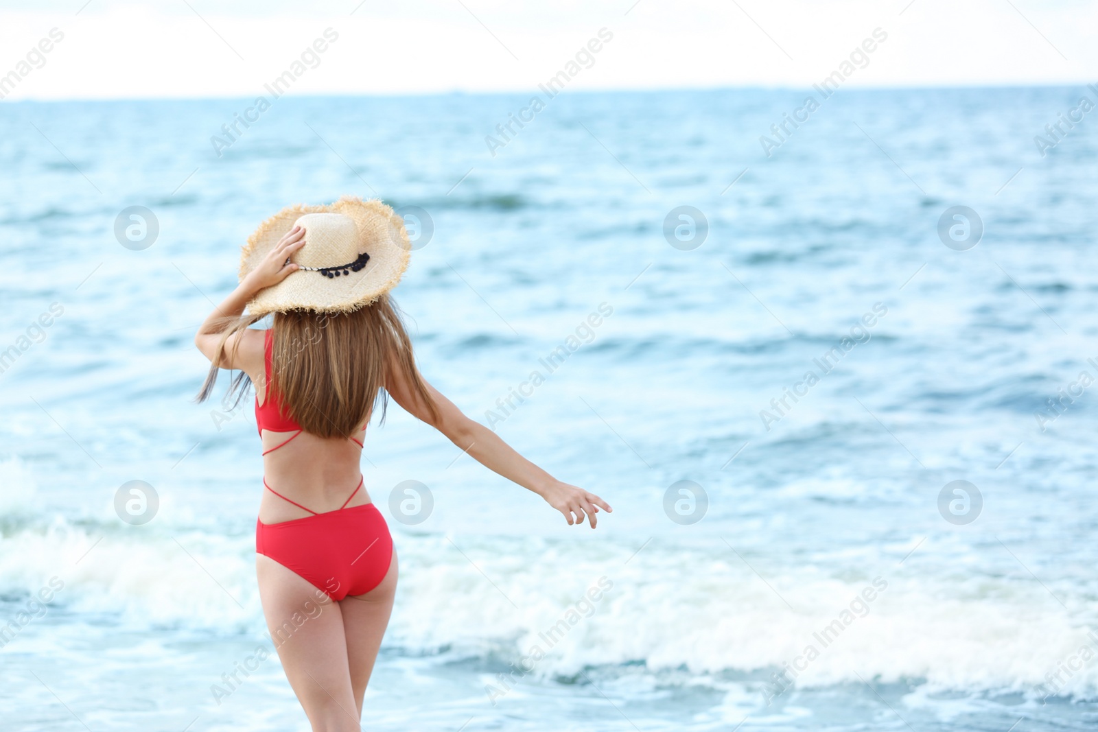 Photo of Attractive young woman in beautiful one-piece swimsuit on beach