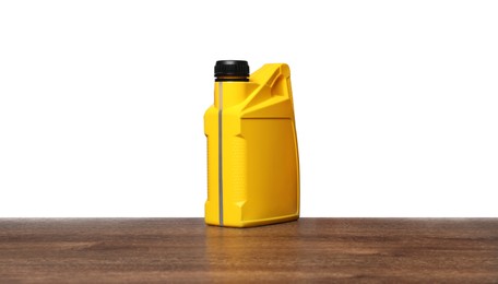 Photo of Motor oil in yellow container on wooden table against white background