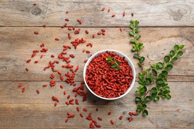 Flat lay composition with dried goji berries on wooden table. Healthy superfood