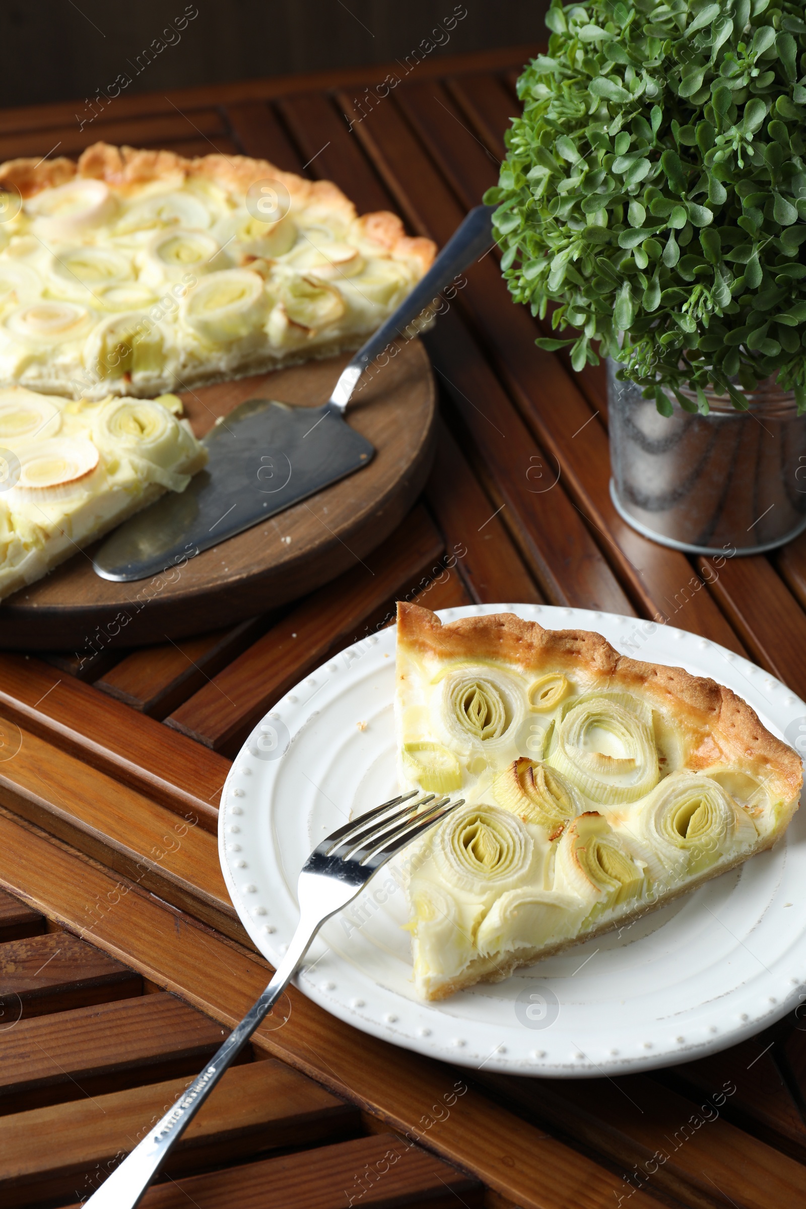 Photo of Tasty leek pie served on wooden table