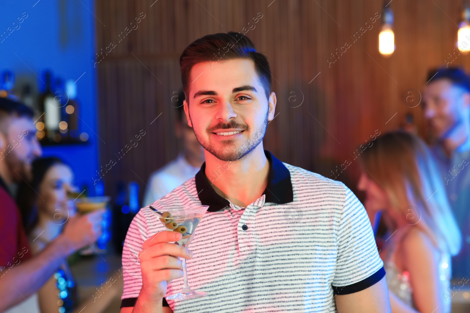 Photo of Young man with glass of martini cocktail at party