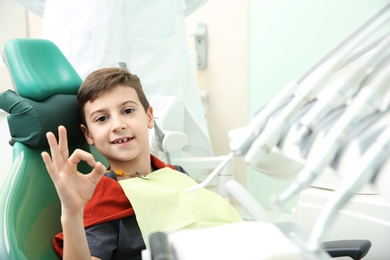 Photo of Happy little boy having dentist's appointment in modern clinic