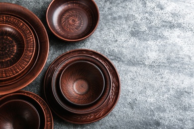 Photo of Set of clay utensils on grey table, flat lay. Space for text