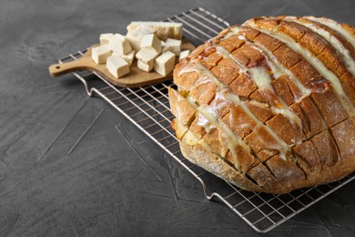 Photo of Freshly baked bread with tofu cheese on black table, closeup. Space for text