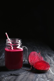 Mason jar of beet smoothie on table, space for text