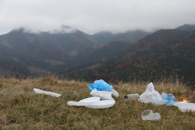 Photo of Plastic garbage scattered on grass in nature