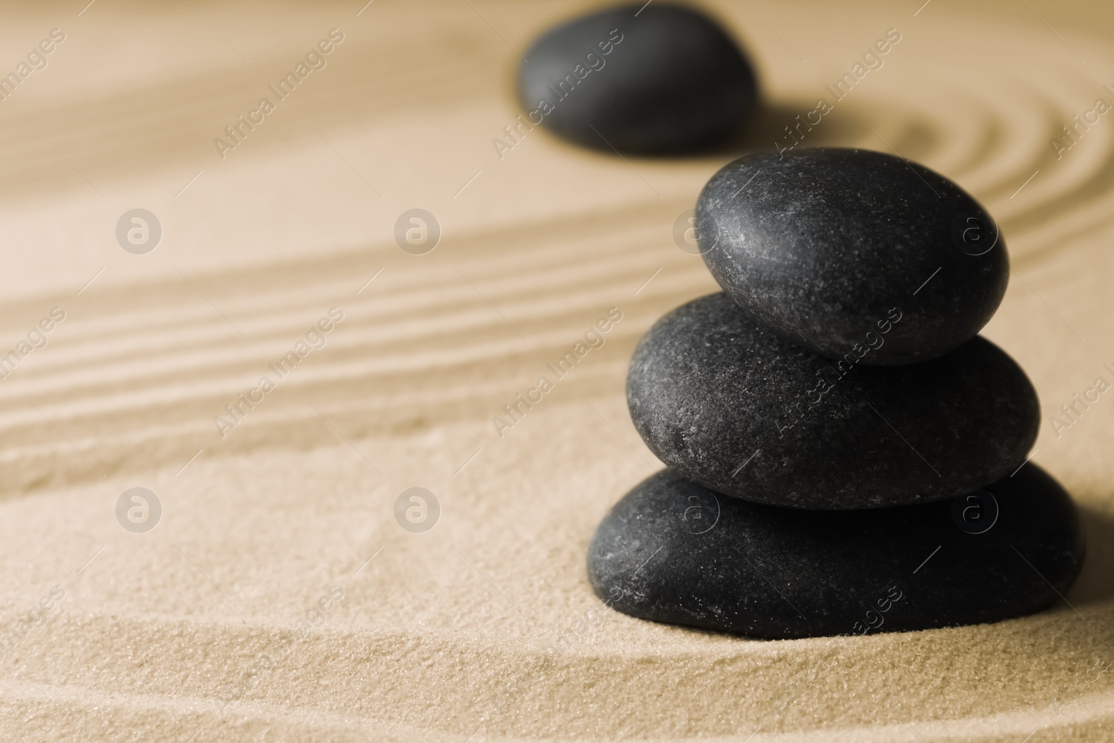 Photo of Stacked zen garden stones on sand with pattern, space for text. Meditation and harmony