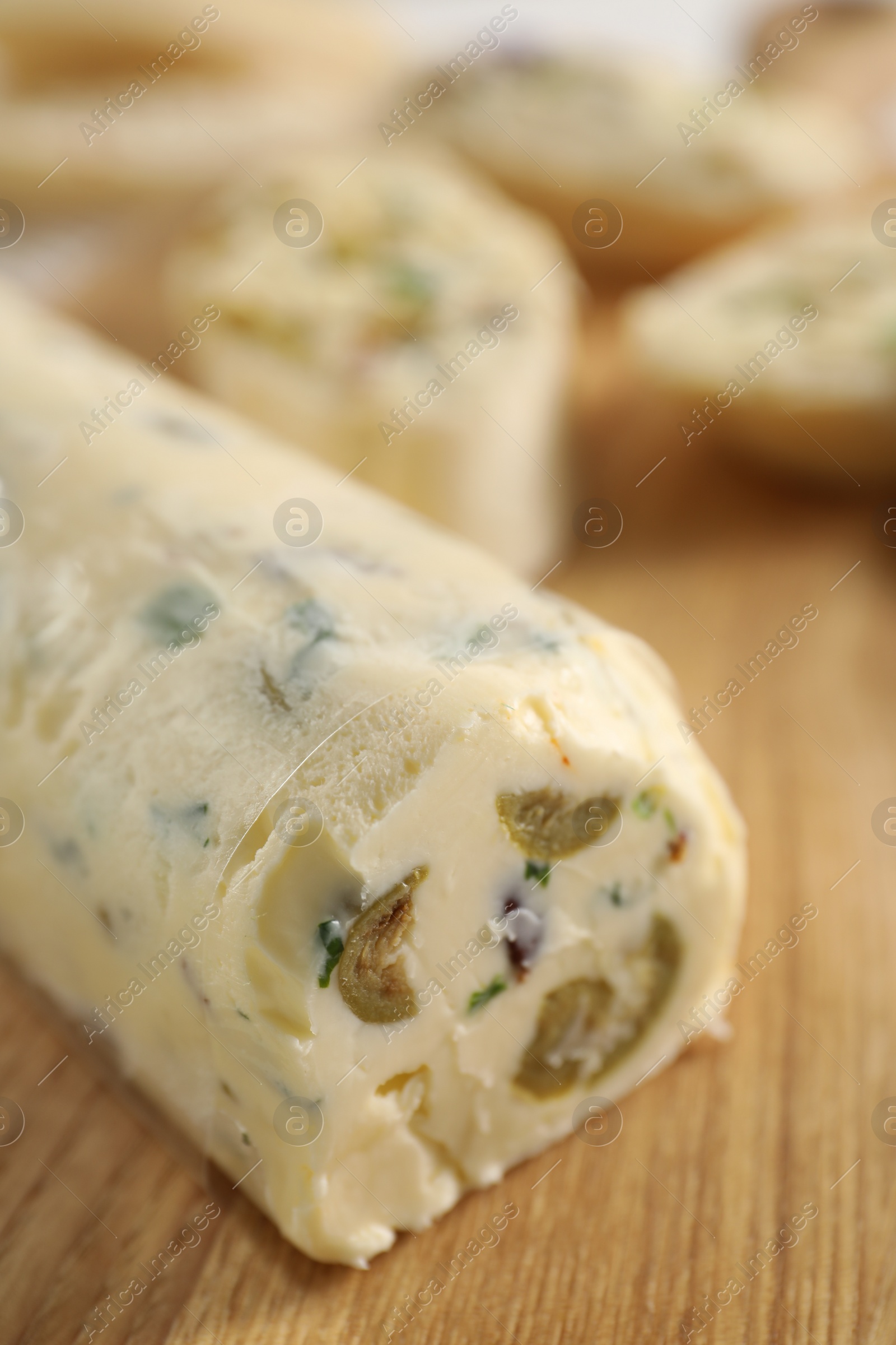 Photo of Tasty butter with olives and green onion on wooden table, closeup