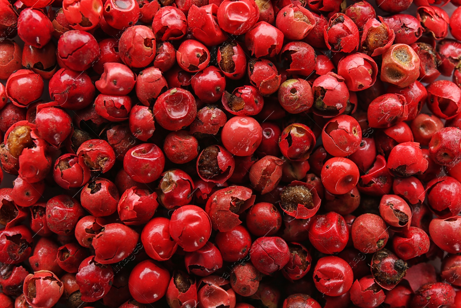 Photo of Red peppercorns as background, top view. Aromatic spice