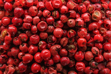 Red peppercorns as background, top view. Aromatic spice